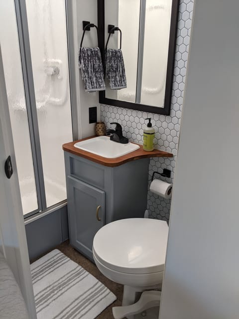 Full bathroom with gravity toilet, storage & shower.  