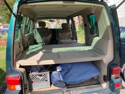 The back bench seat folds down leaving you with the flat space to  put the mattress down and still plenty of storage underneath