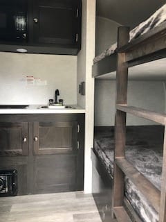 40" wide bunkbeds at front.  Kitchen sink and stove to the left.