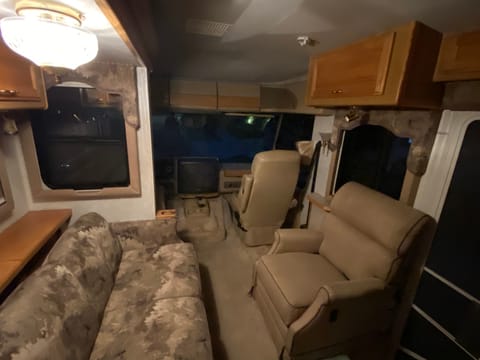 Couch and reclining chair looking towards the front of the RV 