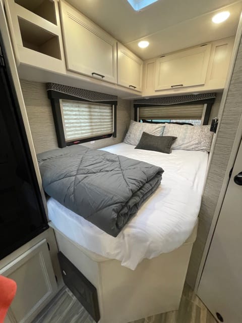 Cozy up in the Queen bed. Windows on both sides provide views during the day and blinds allow for privacy at night. Overhead storage cabinets take advantage of unused space.