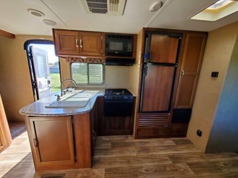 The spacious kitchen has a double sink with plenty of counter space and a ton of storage. It has a 3 burner propane stove/oven, a microwave, large fridge, and pantry with plenty of room.