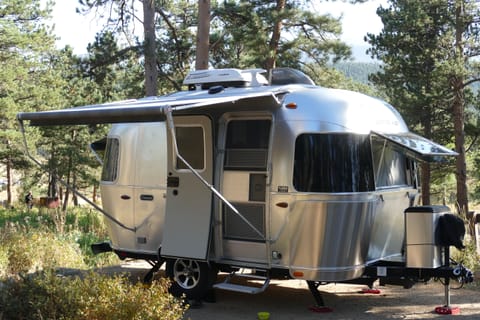 The main awning is large enough to sit under in a sunny campsite. A screen door and wrap around windows provide airflow.