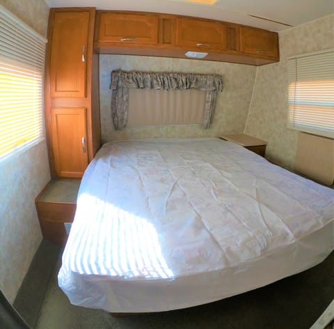 Queen size bed with plenty cabinets for shoes and clothing.