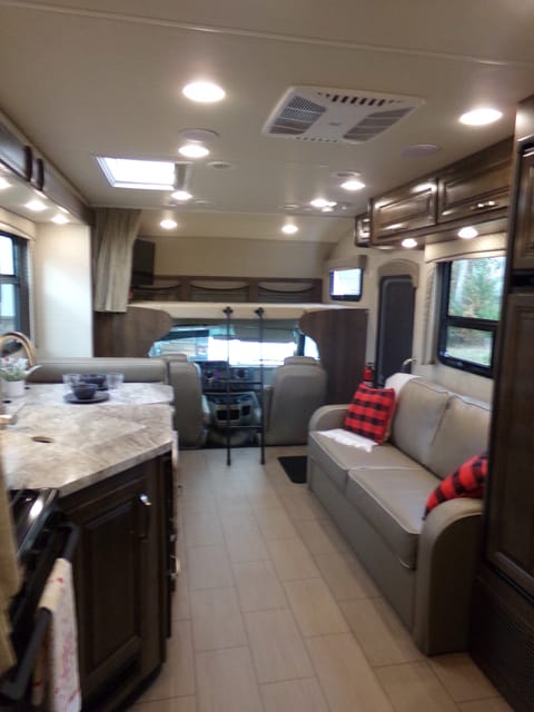 Another view of the living area, there is a queen-size bed above the cab with a huge TV.  