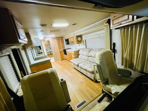 This  view looks from the Captain chairs to the back of the RV. It gives you a nice view of the beautiful hardwood floors and spacious living area.