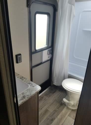 Bathroom with storage, shower/tub combo, secondary exterior door 