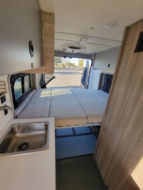  The bed is Murphy bed style and one can choose to travel with it down our up. Plenty of storage under the bed as well as above it in the cabinets.