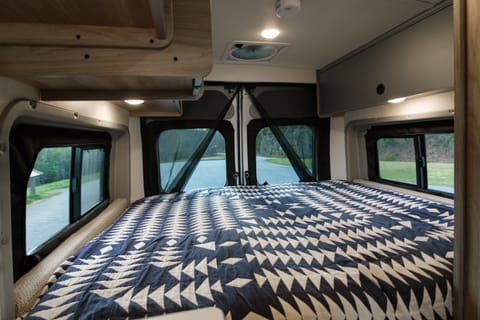 Queen-sized bed; storage cabinets that stay open through magnets on the ceiling; blackout shades on all windows/back doors are easily zipped up. 