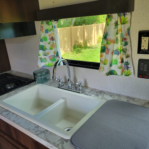 Kitchen sink with window and dish washing mat.