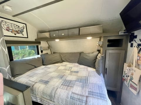 RV short queen w/ easy to access outlet/usb ports, and shelves. Shelf above bed has cubby baskets that can be pulled out for easy storage and access.