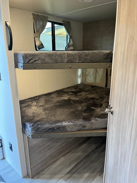 The top bunk can fit two small children/teenagers with a weight capacity of 300 lbs. The bottom fits two adults with a weight capacity of 600 lbs.