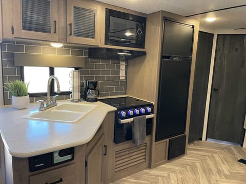 Kitchen area, with fridge, freezer, microwave, 3 burners and small oven.