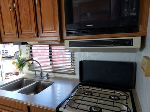 Kitchen highlights: double sink, 3 burner stove, microwave, oven.