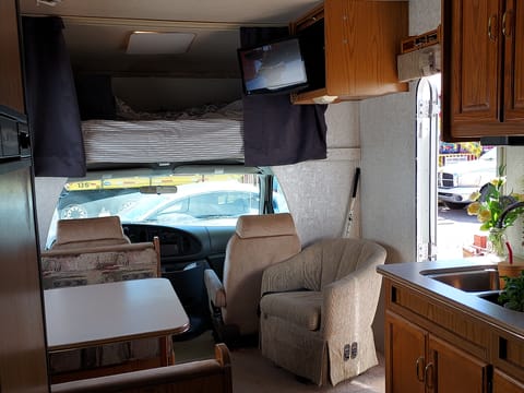 TV above chair fits into cabinet. When out can be moved to be viewed throughout most of the RV.