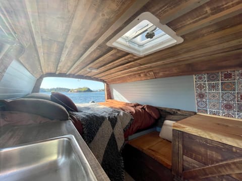 Inside sleeping area, 2 working/cooking tabletops and a sink, roof vent and live edge sitting area.