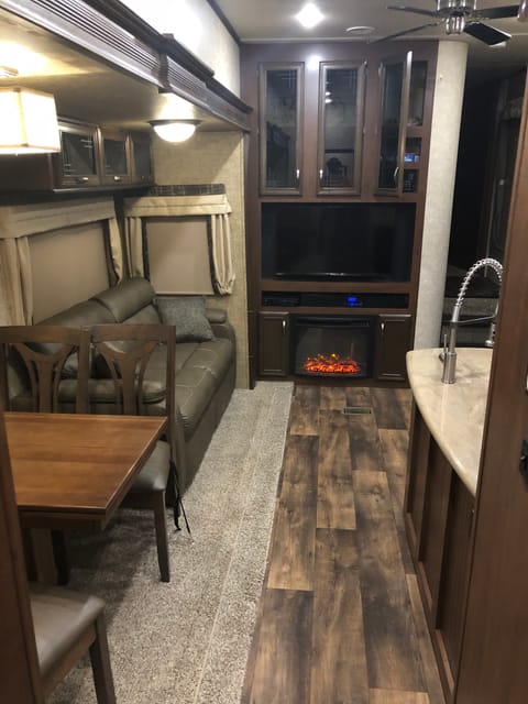 Main area with fireplace, pull out sofa bed and ceiling fan.