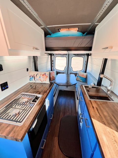 The Maui has sleeping arrangements for four people! The bottom is a dinette that converts to a queen bed and the top is a full bed on a lift that descends from the ceiling.  