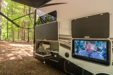 Under the full-length awning, you can enjoy cooking outdoors while watching TV.  Keep drinks cool and close at hand in the outdoor kitchen.