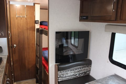 Twin beds behind kitchenette with electric space heater (with remote controlled deluxe faux wood fireplace lighting - fancy)