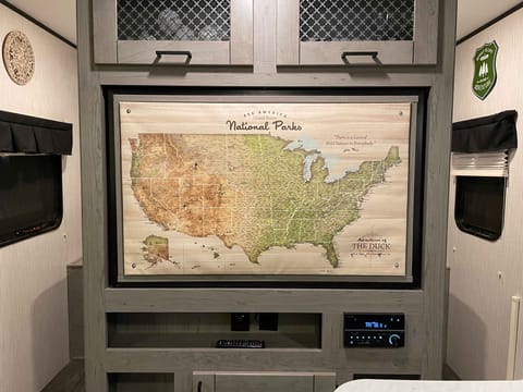 Customized push-pin map is on the back of swivel TV
