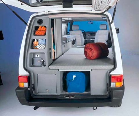 Stock photo showing the rear shower sprayer, closet, bed, cargo area, and front seats turned around for camping!