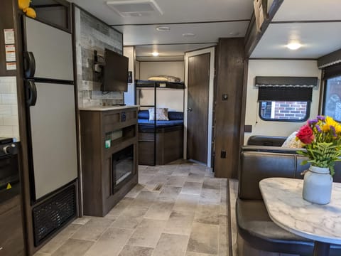 Taken from the bedroom side. L to R: Double door refrigerator, 2 double bunk beds, the bathroom door, closet, sofa, dinette area.