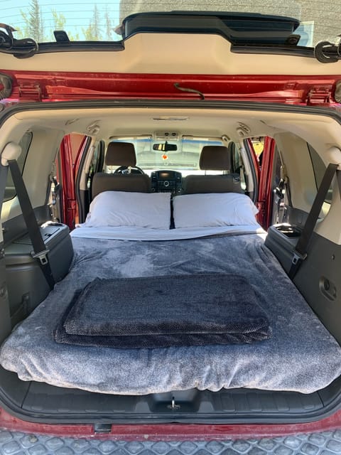 full-size sleeping area in rear with seats down. Bedding included.