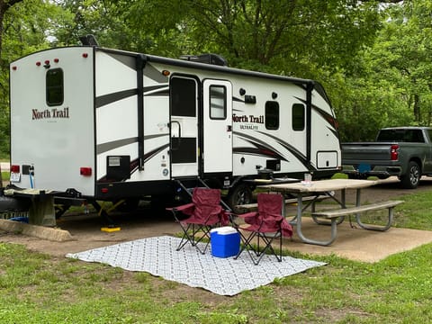 The length of the travel trailer is 28' from tongue to end of the spare tire. 2 camp chairs, outdoor rug and a table cloth with clips are provided. 
