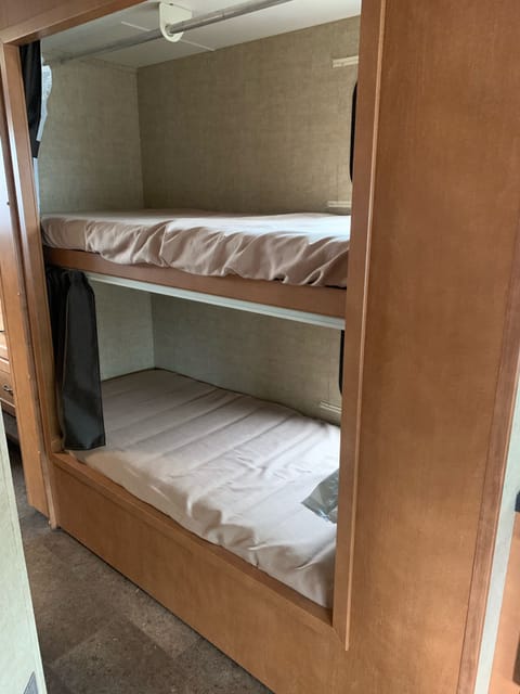 Bunks with windows and privacy screening.  Top bunk folds up for more room.  Rack for hanging.