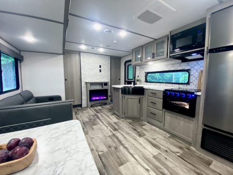 Beautiful, spacious kitchen... view from dining table. Digital fireplace can actually heat the entire camper!