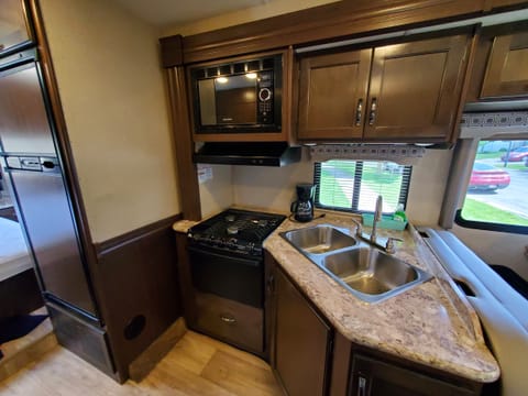 Propane stove and oven, microwave, fridge and freezer, coffee maker, and the kitchen sink