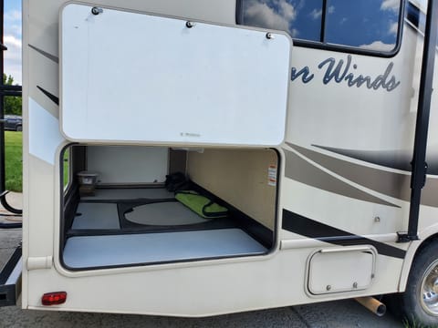 Spacious storage under camper with folding camp table