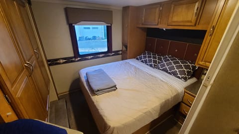 Queen bed, tons of storage and extra blankets in cabinet above bed