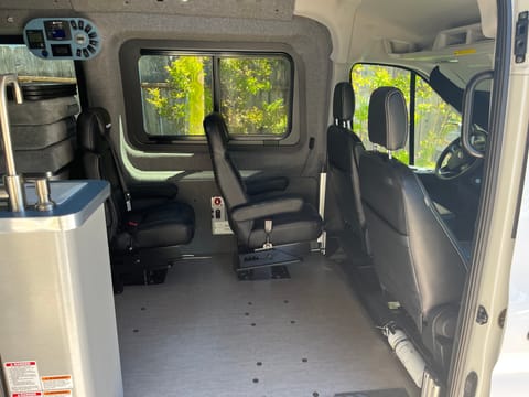 VanHaus ModVan optional chair set up.  Shows lower bed cushions stacked and sink.  There is an option to add two more seats if needed.