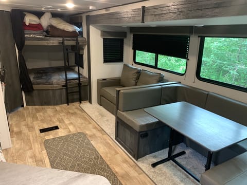 Kitchen table ,couch, and bunk beds .
Bathroom is the door next to bunk beds. Kitchen table and couch both pull out into  a bed.