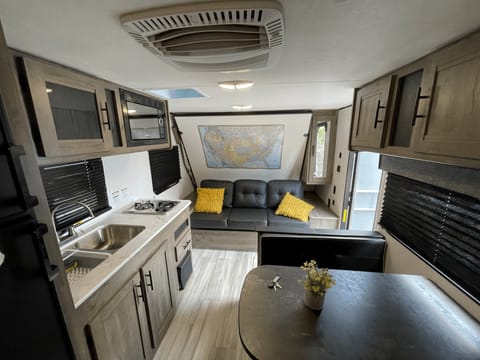 Sofa, dinette area, fridge and kitchen with stove and microwave