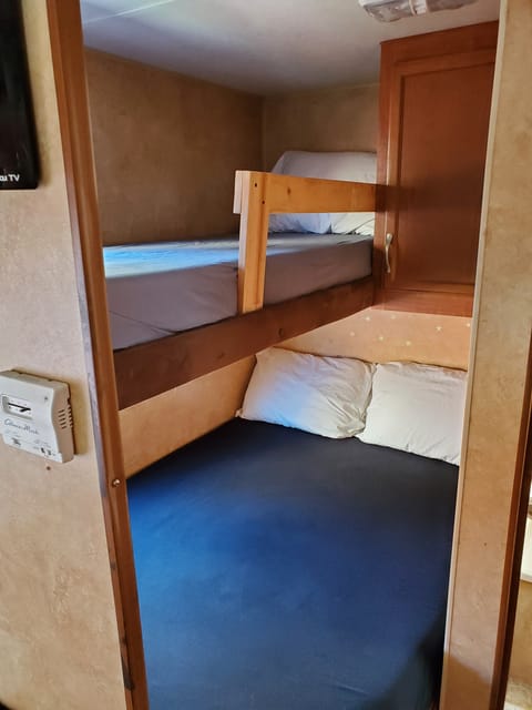 Twin over full bunks. Wall mounted TV over dinette swivels to be viewable in the bunk area. 
