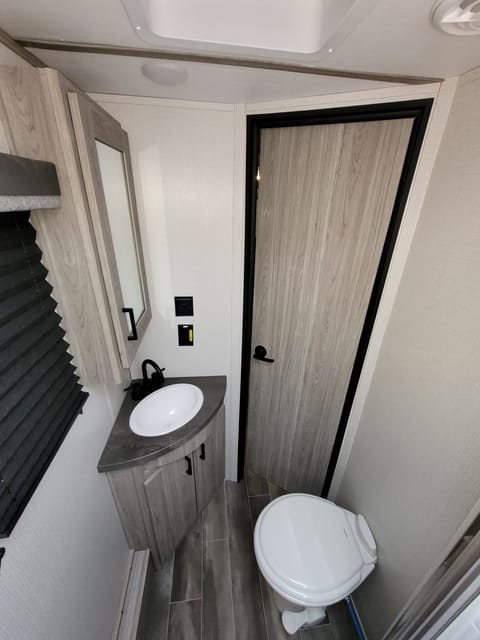 Porcelain Toilet, Sink with storage below/ Medicine Cabinet with Mirror. Solar/Inverter powered Outlets.  