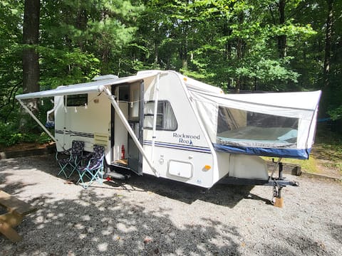 Exterior of camper setup with beds out and awning.