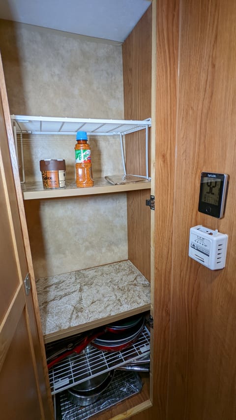 The pantry can fit a lot of food, and there is a thermostat for indoor and outdoor temperatures and the heater controls there too