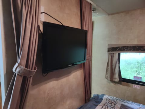 Two wall mounted tvs, one in the sleeping area and the other in the living space.
