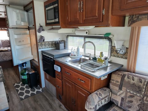 Cutting board over cook top for extra counter space.   3 burner gas stove and gas oven.