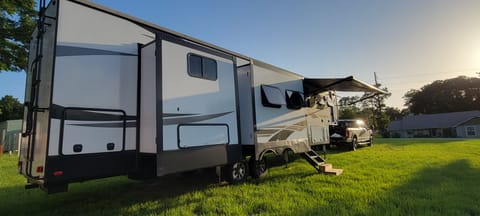 Beautiful BigHorn Traveler Fifth Wheel with awning out.  Two slides on front and 3 slides on back for a roomy interior.