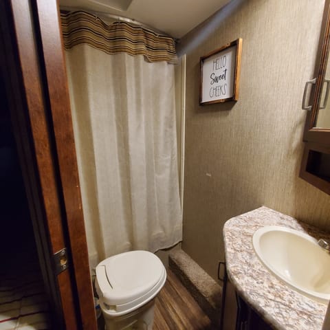 Restroom includes a shower/tub combo. Air vent w/fan. The commode has the handle on the right side. There is storage under the sink as well as a medicine cabinet above. 