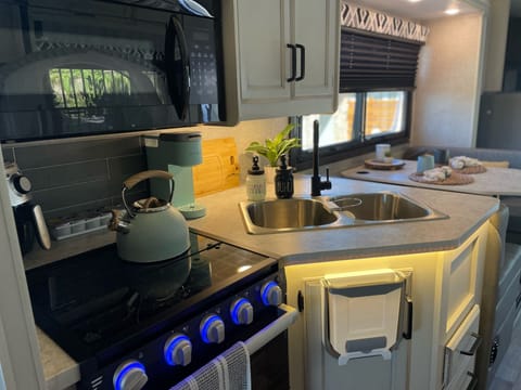 Oven, gas range, microwave, Keurig, air fryer, and cabinets stocked with kitchen utensils for a traveling chef! 