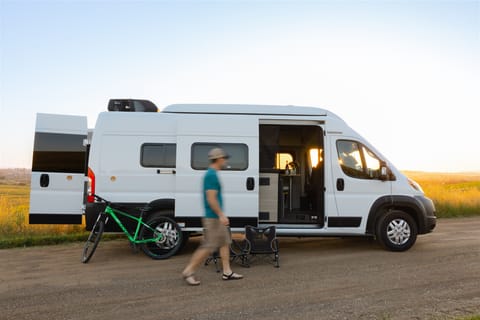 The exterior of van with optional adventure add-ons. Adventure add-ons: (2) camping chairs and (2) Giant mountain bikes on Thule hitch bike mount.