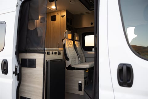 Exterior with a view of the fridge and rear passenger seats. The fridge is powered by solar.