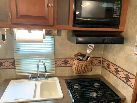 Gas Stovetop with exhaust fan and kitchen sink. Microwave 