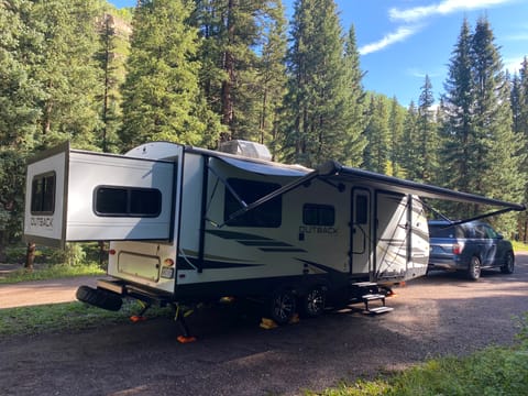 Meet HarVee.  Your cozy, comfy getaway for a mountain or desert retreat.  Sleeps 5, amenities galore, heating and A/C.
Left to Right:  rear slide which is the King Bed, window over Dining Table, smaller window is the Kitchen, Front door over steps, fold-down garage door creating ramp up into Garage/Bunk room, 20' lighted awning.